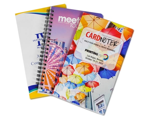 Two spiral notebooks featuring bright umbrellas, showcasing a playful yet professional swag in business.